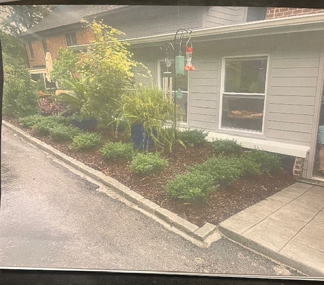 A picture of a house with a garden in front of it.