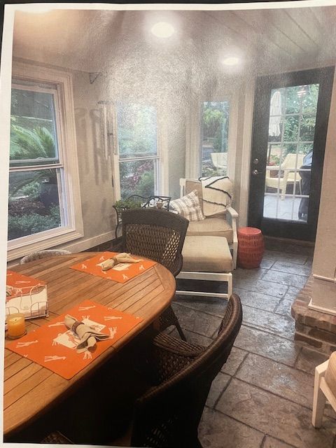 A picture of a living room with a table and chairs