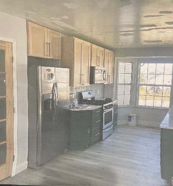 A kitchen with stainless steel appliances and wooden cabinets