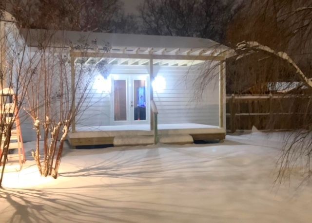 A house with a porch in the snow at night