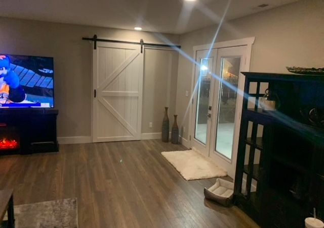A living room with sliding barn doors and a flat screen tv
