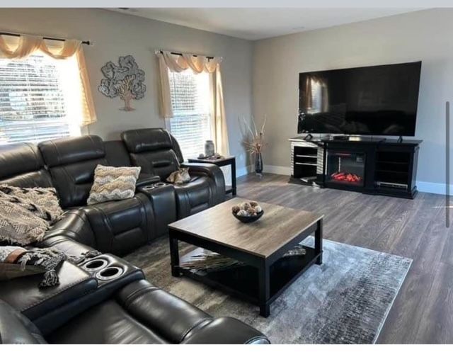 A living room with a couch , coffee table , television and fireplace.