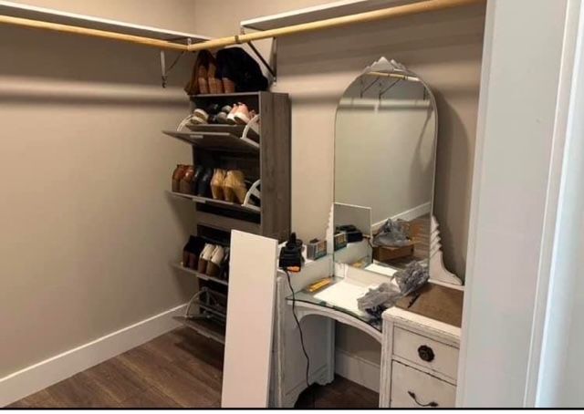 A walk in closet with a dresser and a mirror