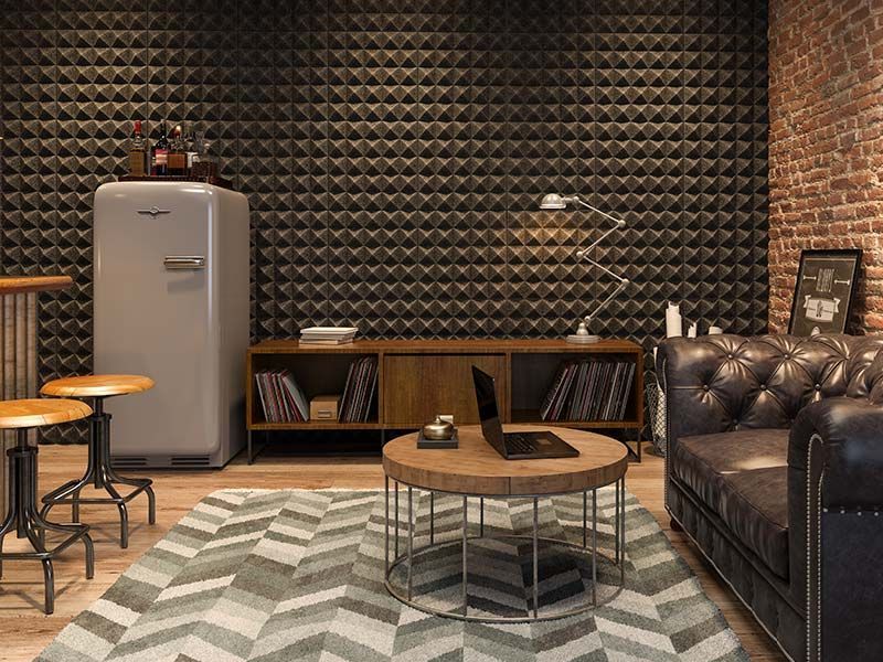 A living room with a couch , coffee table , laptop and refrigerator.