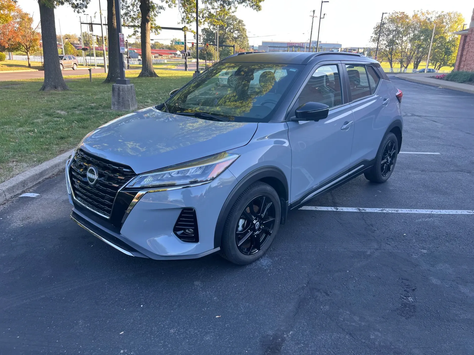 Gray Nissan Kicks SUV parked on asphalt. Black accents, black wheels, dark roof.