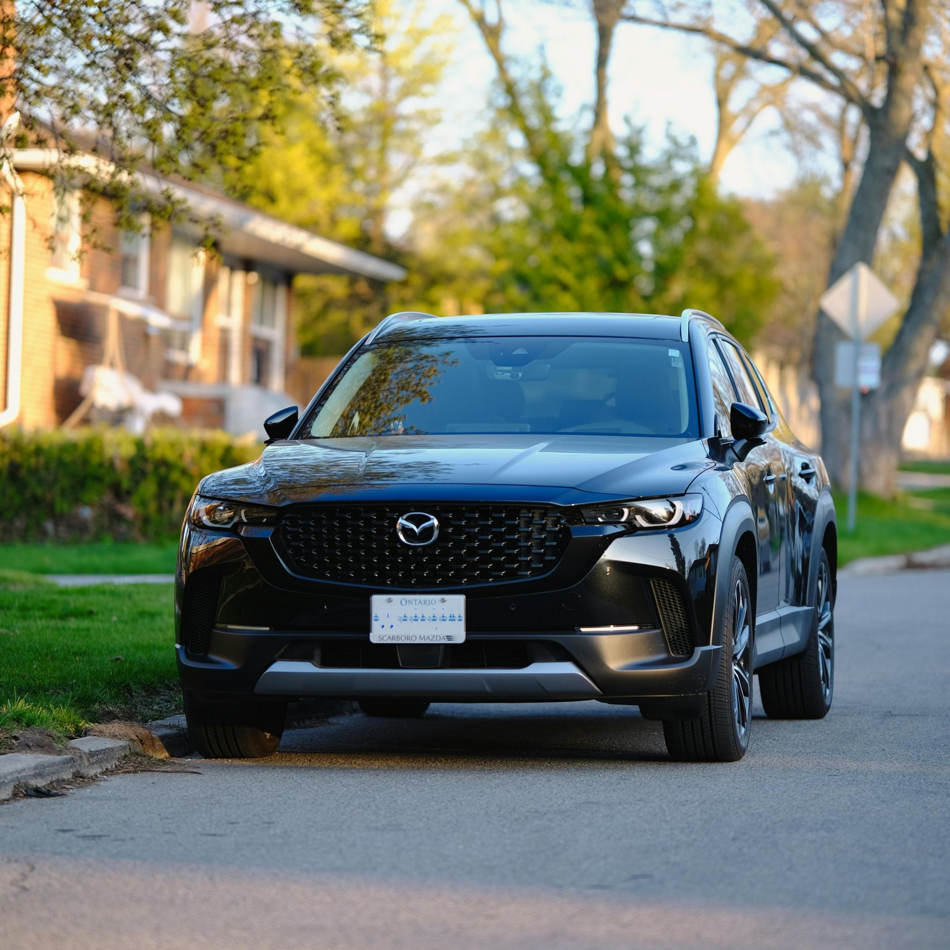 Black Mazda CX-50 parked on a residential street.