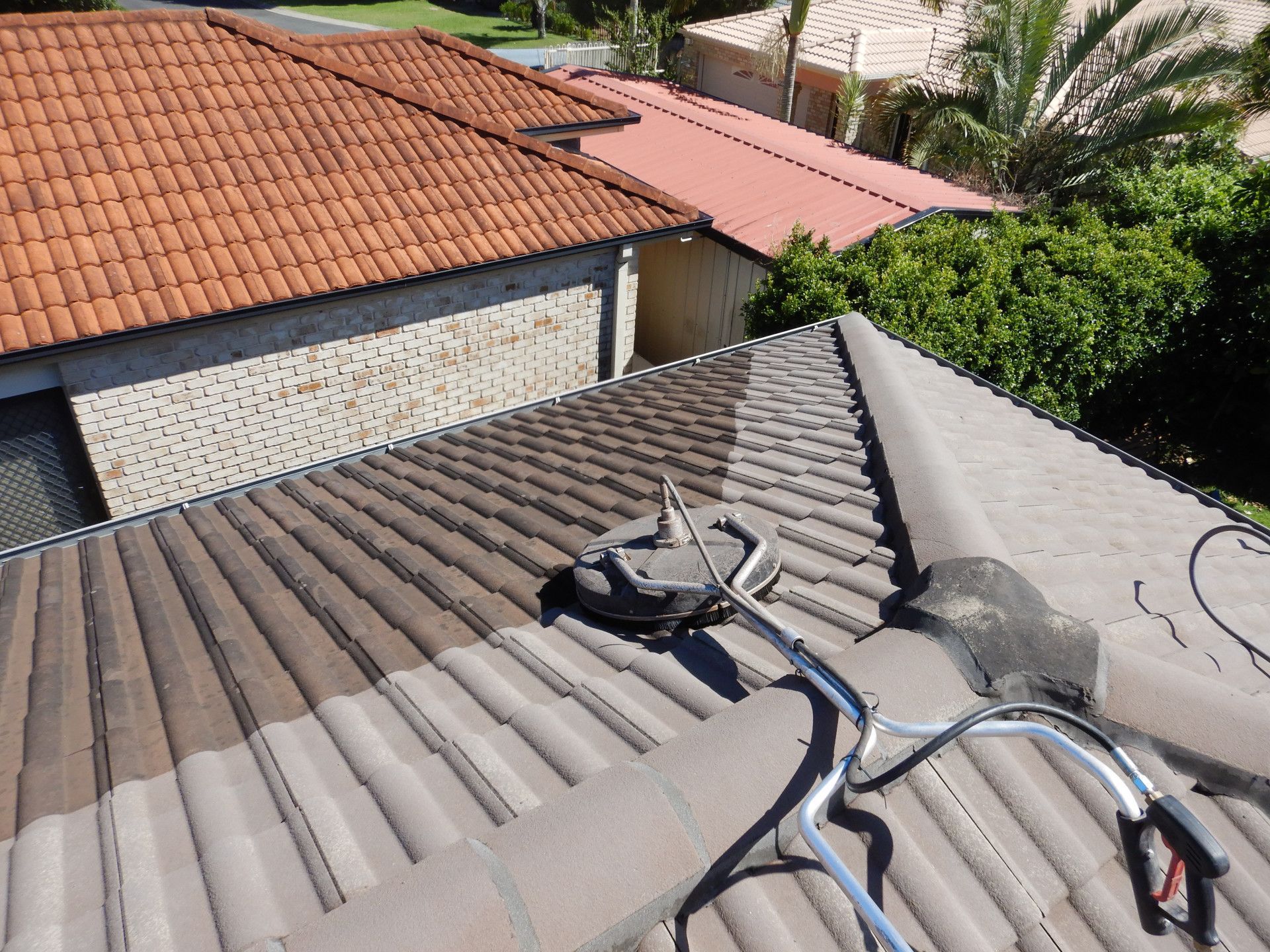 A Pressure Cleaner Sitting On Top Of A Roof — Gold Coast Roof Repairs in Mudgeeraba, QLD