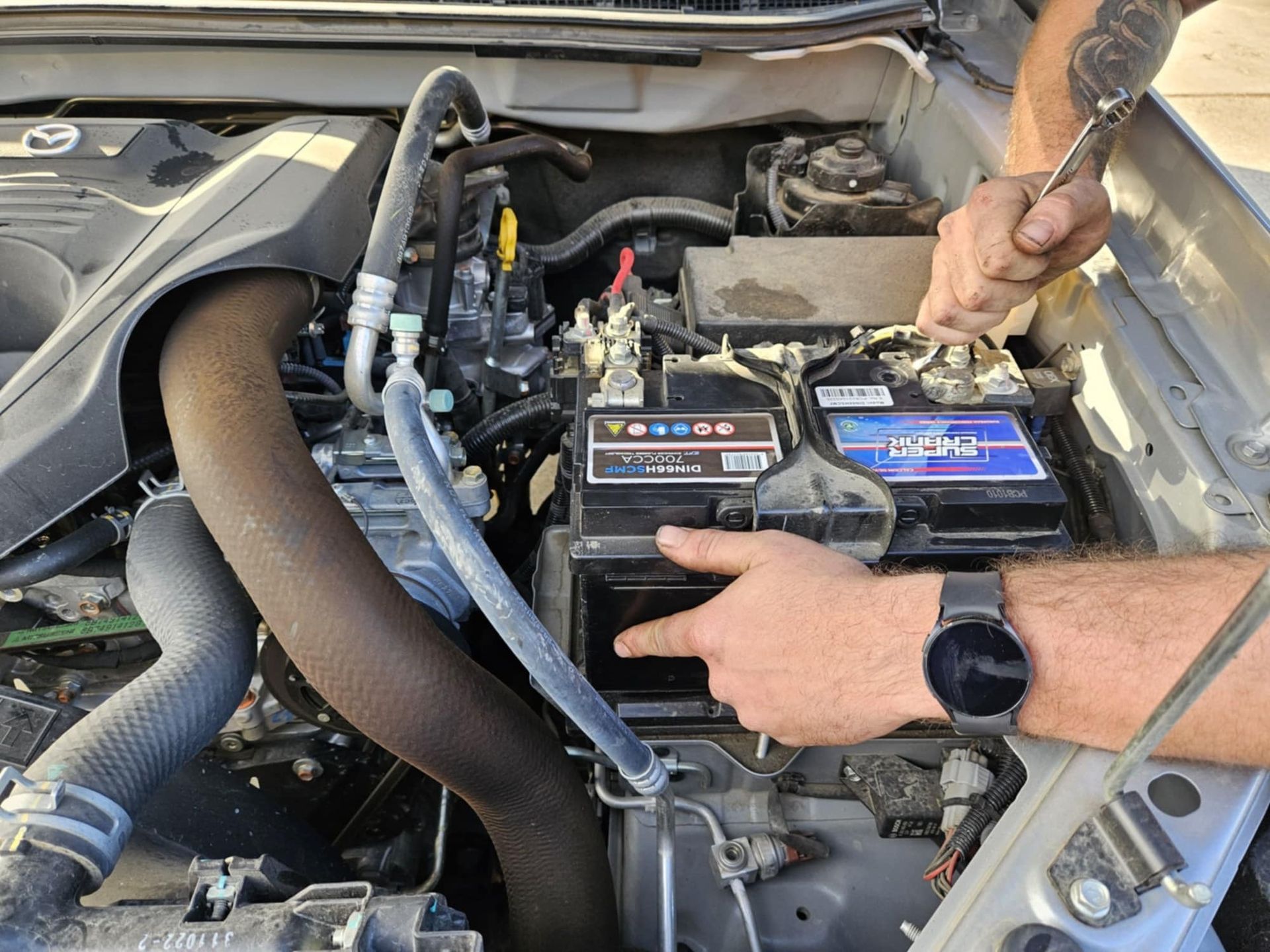 A Man Is Working On The Engine Of A Car — SRG Automotive and Marine in Aitkenvale, QLD
