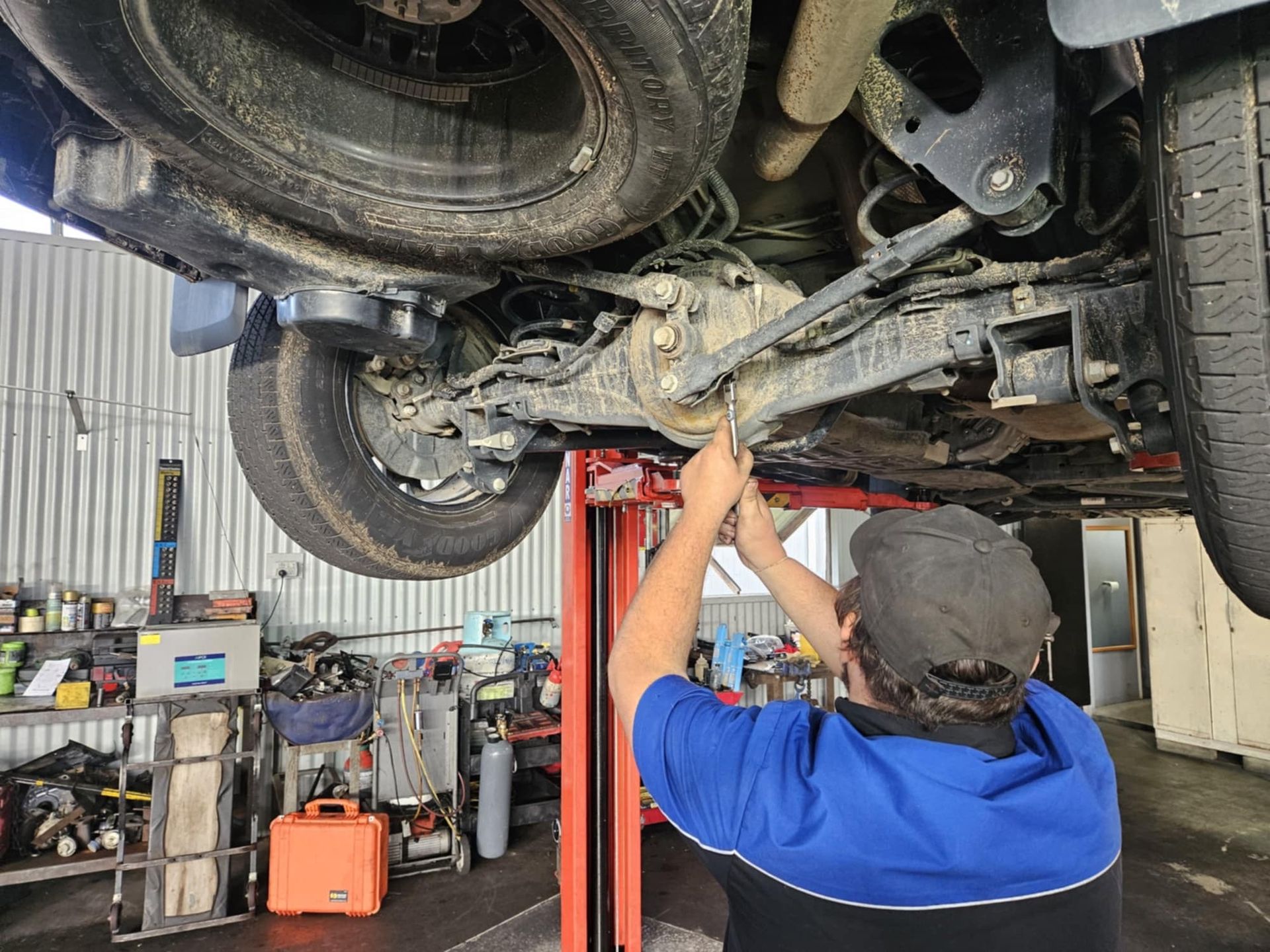 A Man Is Working on A Computer in A Garage — SRG Automotive and Marine in Aitkenvale, QLD
