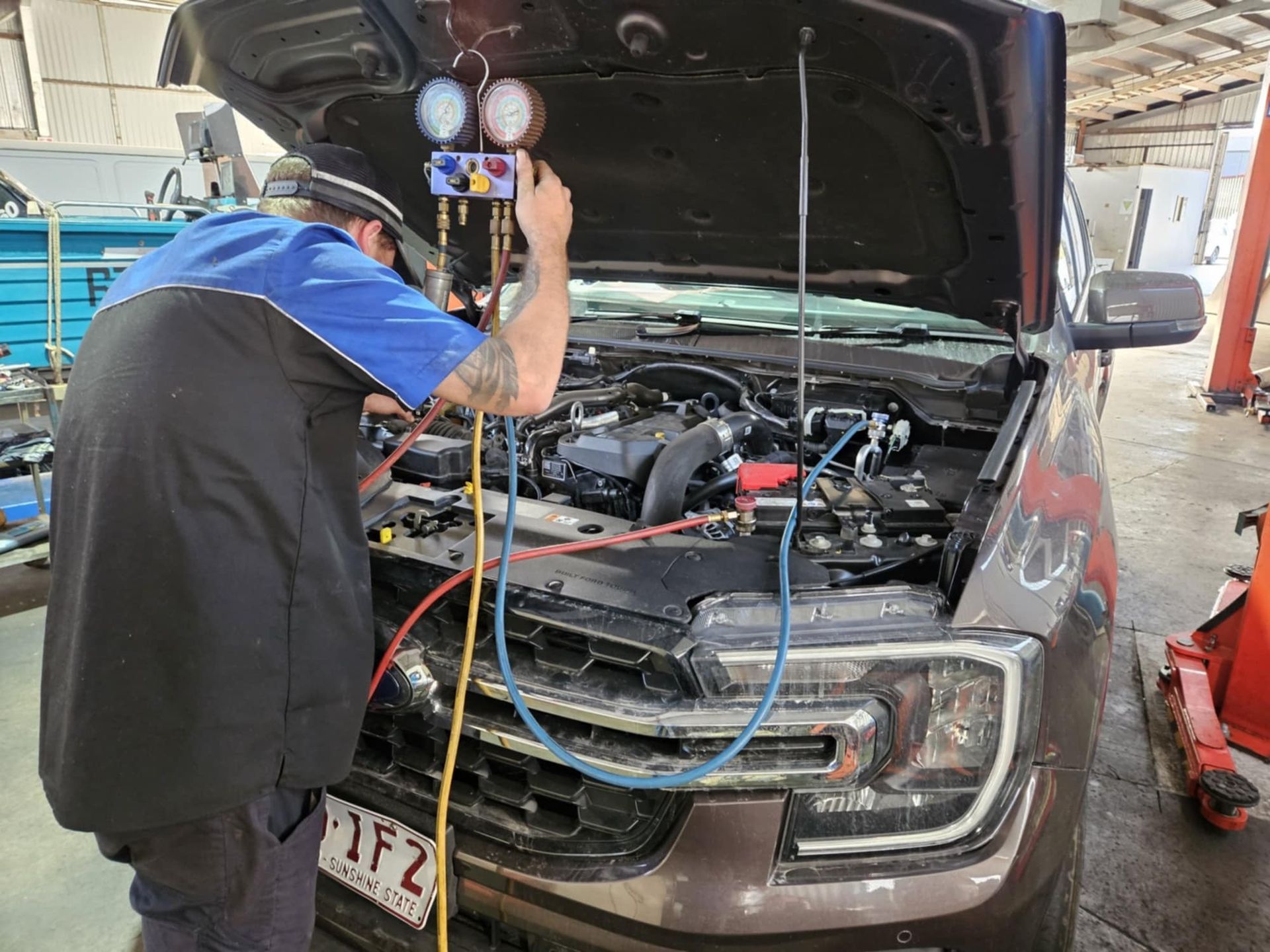 A Man Wearing A Welding Mask Is Working On A Car In A Garage — SRG Automotive and Marine in Aitkenvale, QLD
