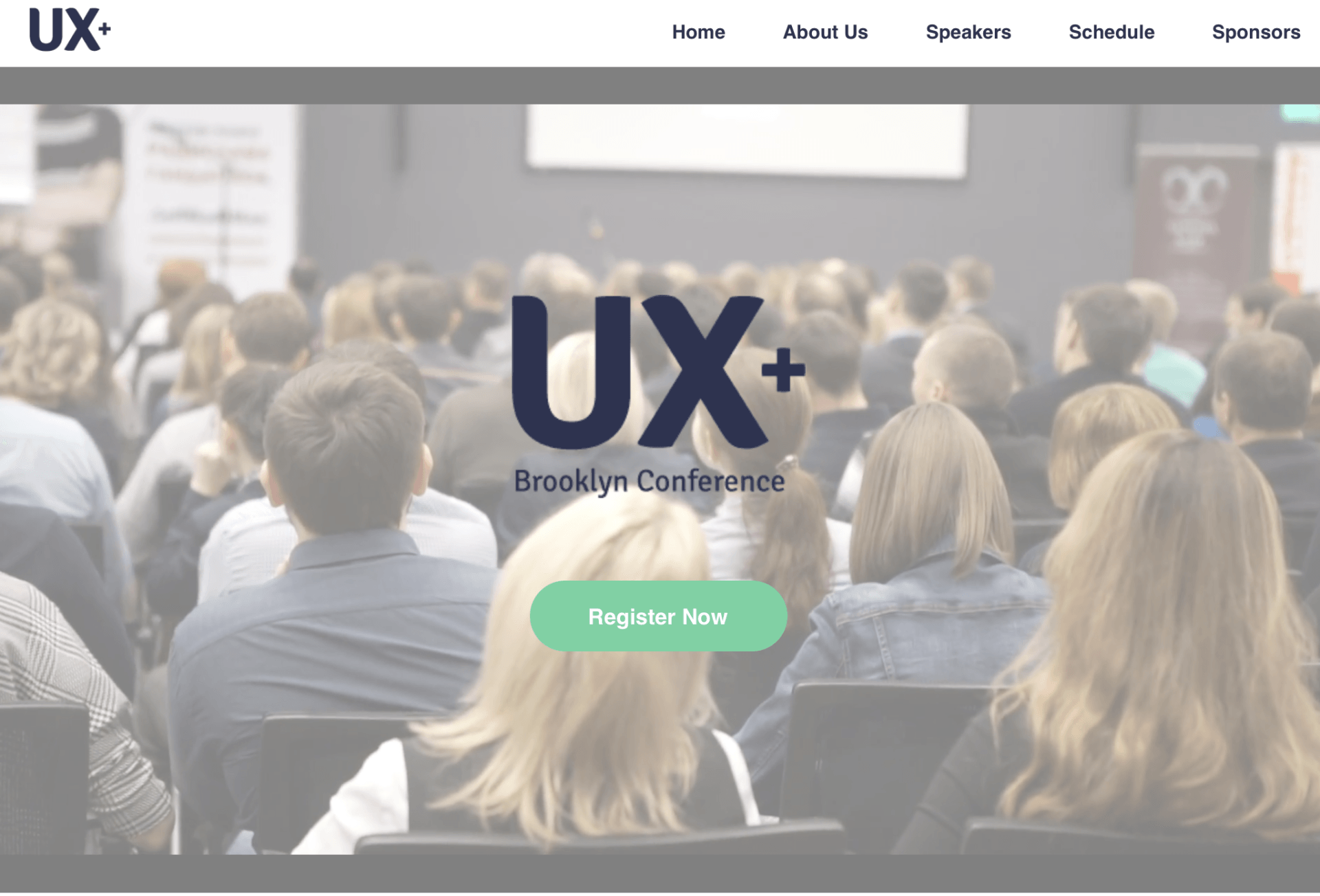 A blurred image of a group of people sitting in a lecture hall.