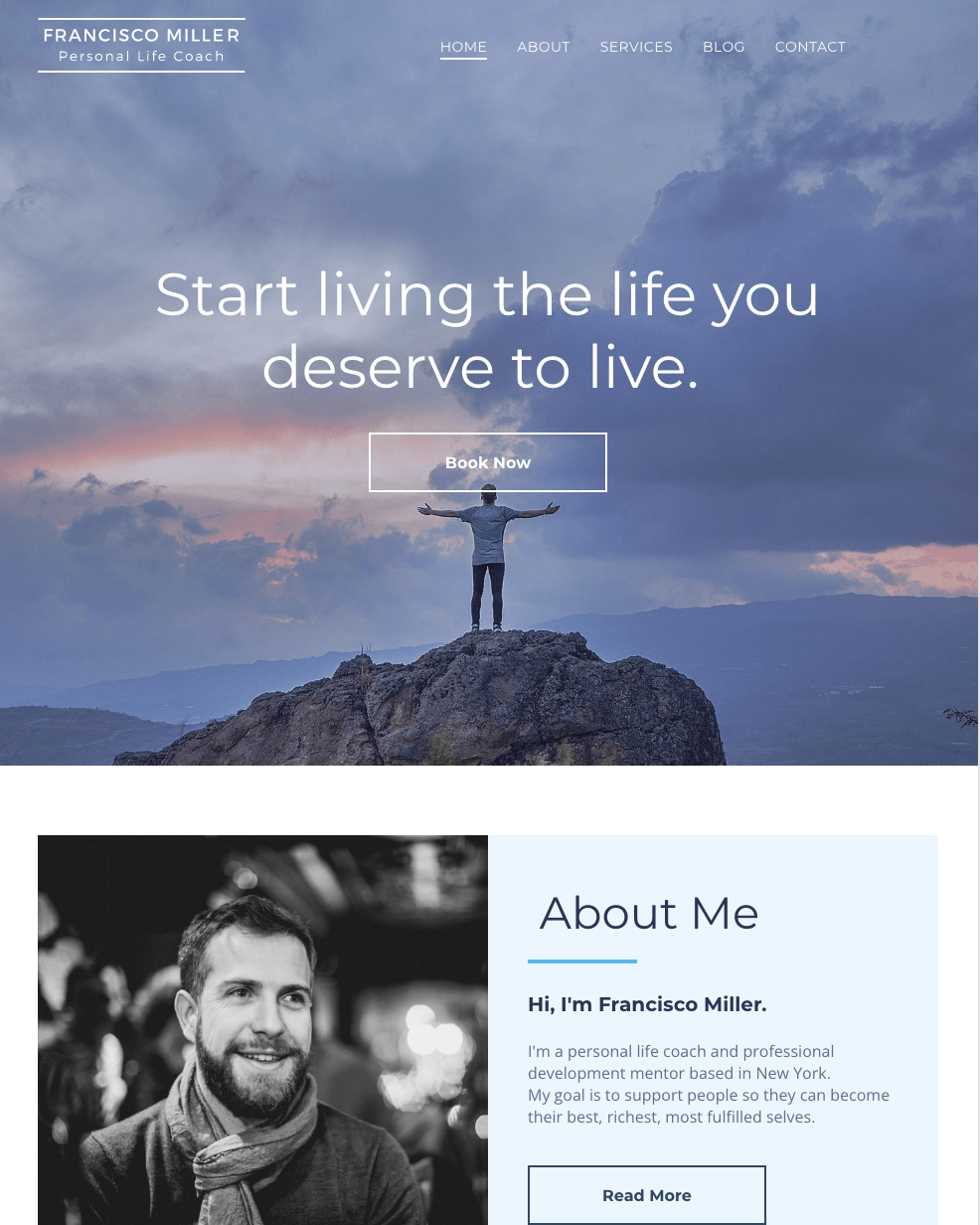 A man is standing on top of a mountain with his arms outstretched.