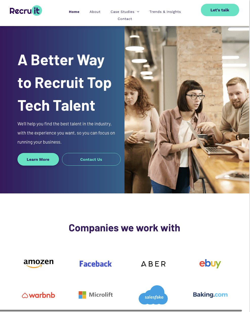 A group of people are sitting around a table looking at laptops.