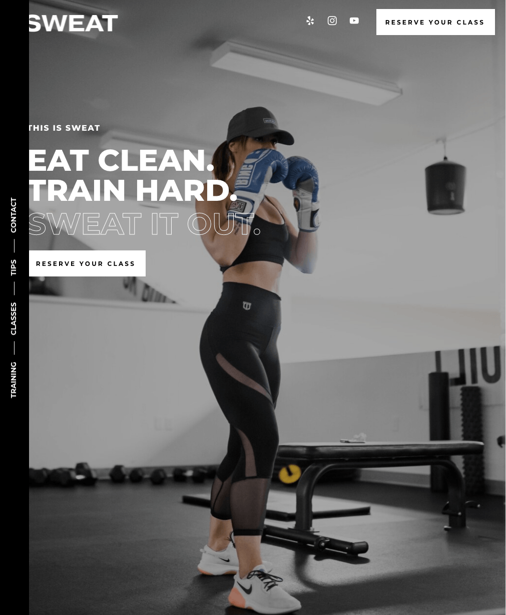 A woman wearing boxing gloves is standing in a gym.