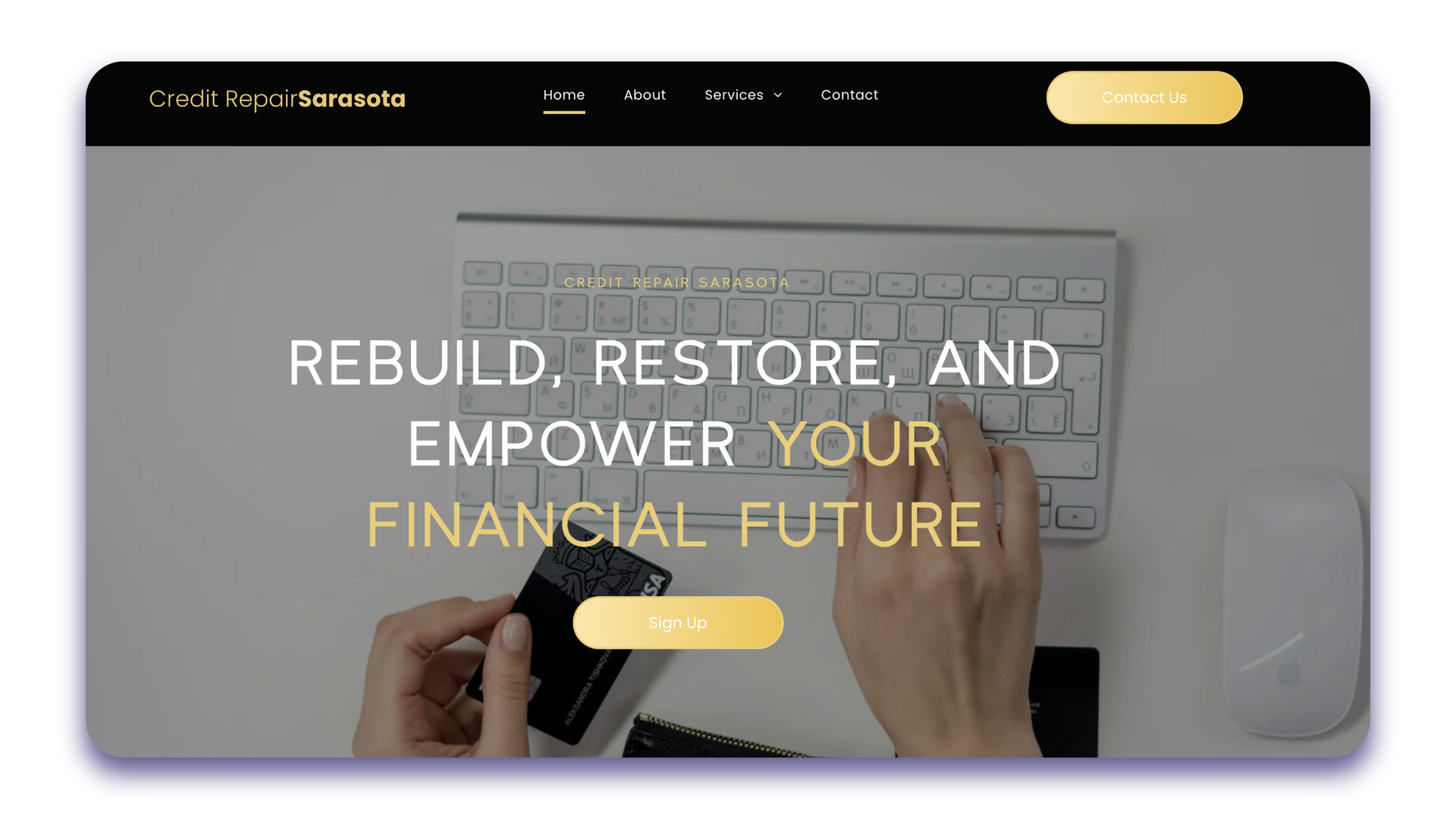 A person is typing on a keyboard and holding a credit card.