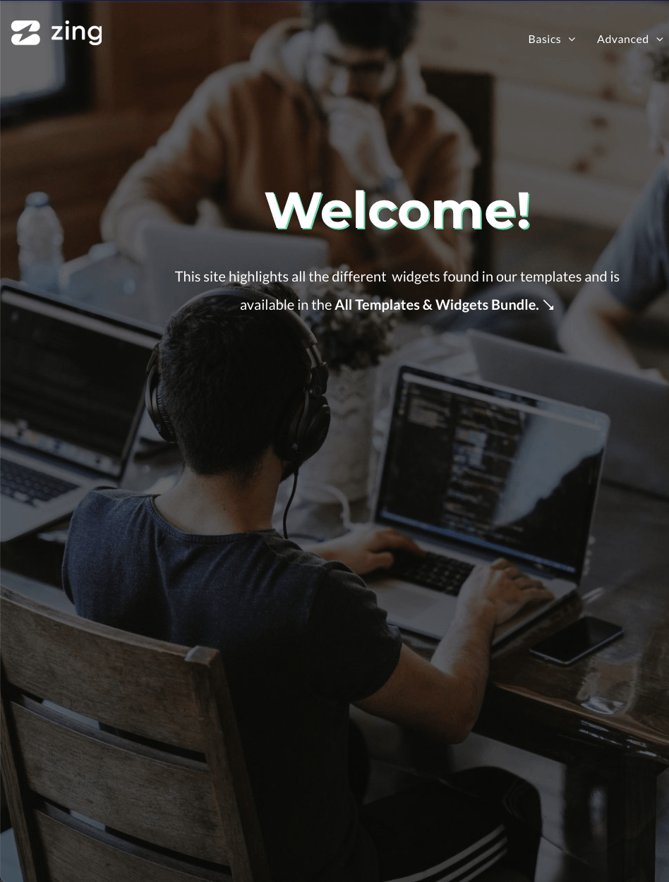 A man wearing headphones is typing on a laptop computer