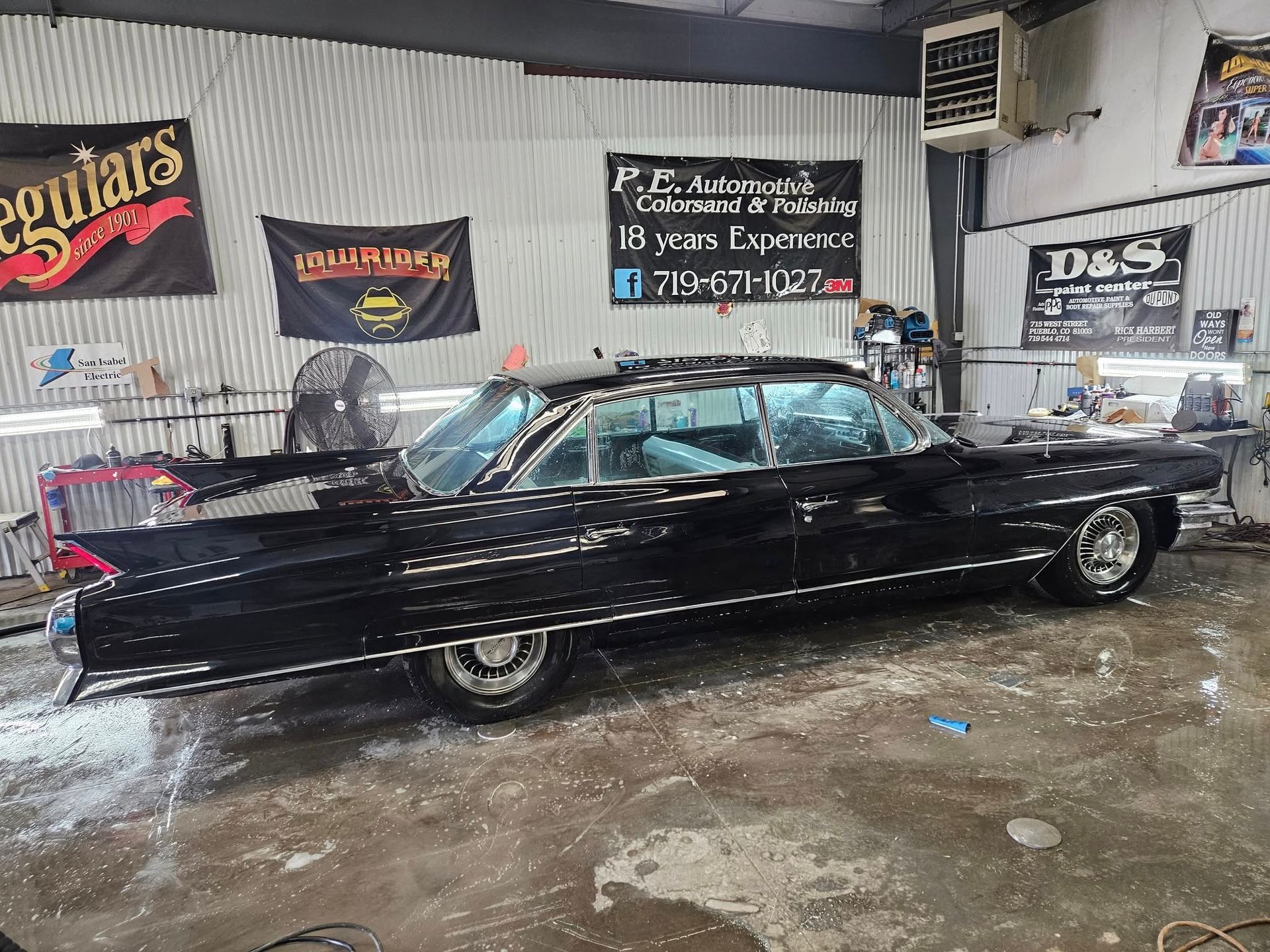 Black classic car in a detailing shop.