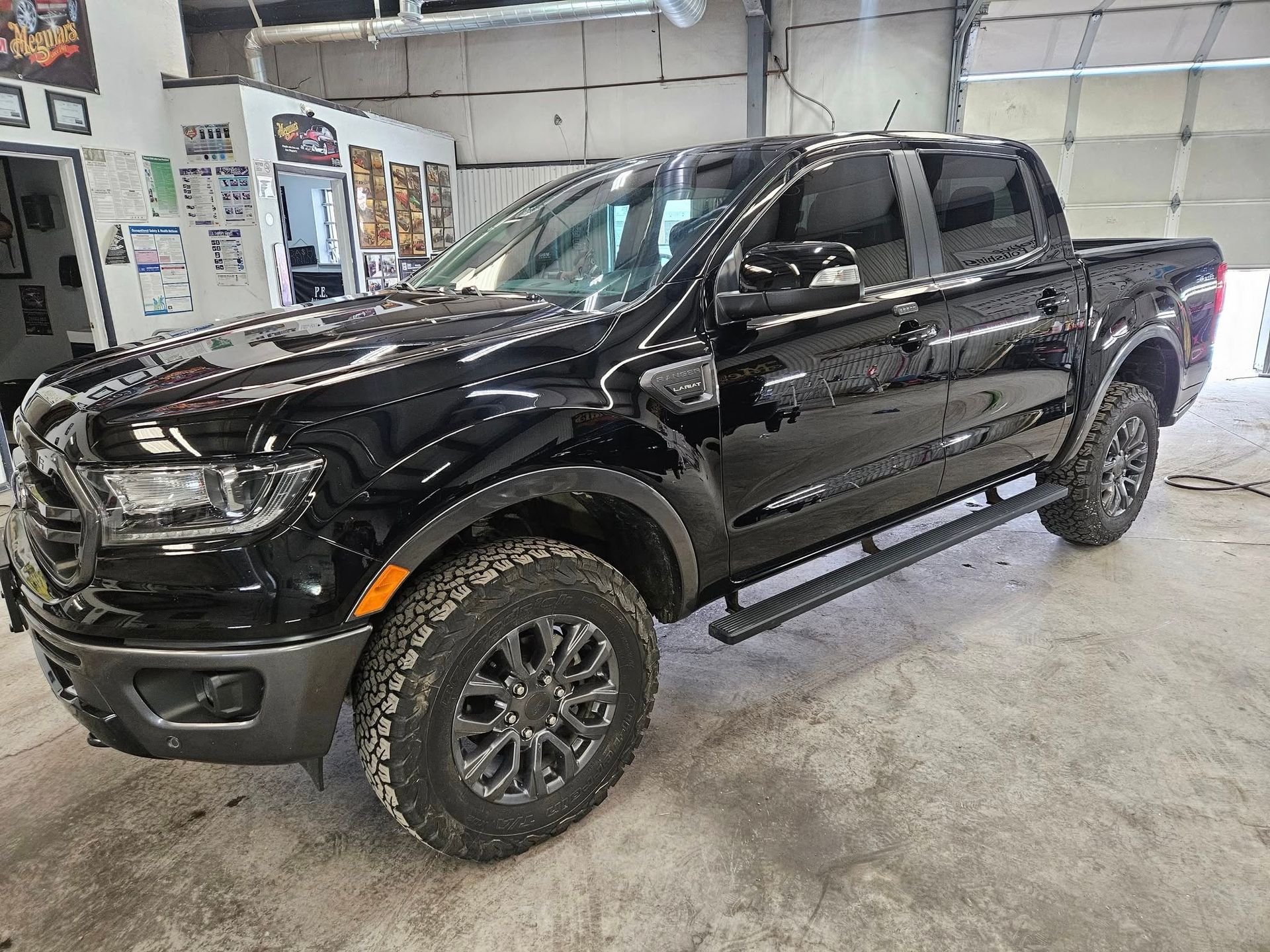 Black Ford Ranger pickup truck in a garage.