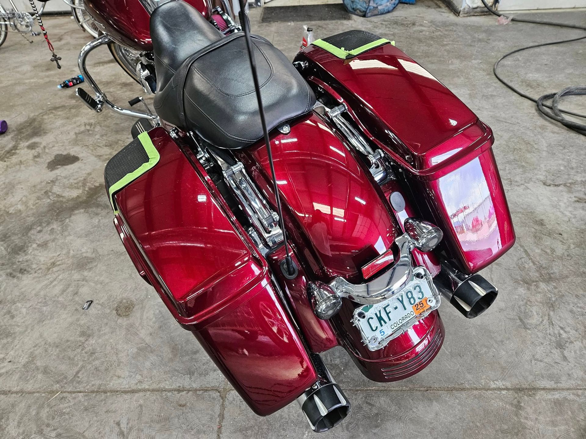 Red motorcycle with saddlebags, black seat, and license plate.