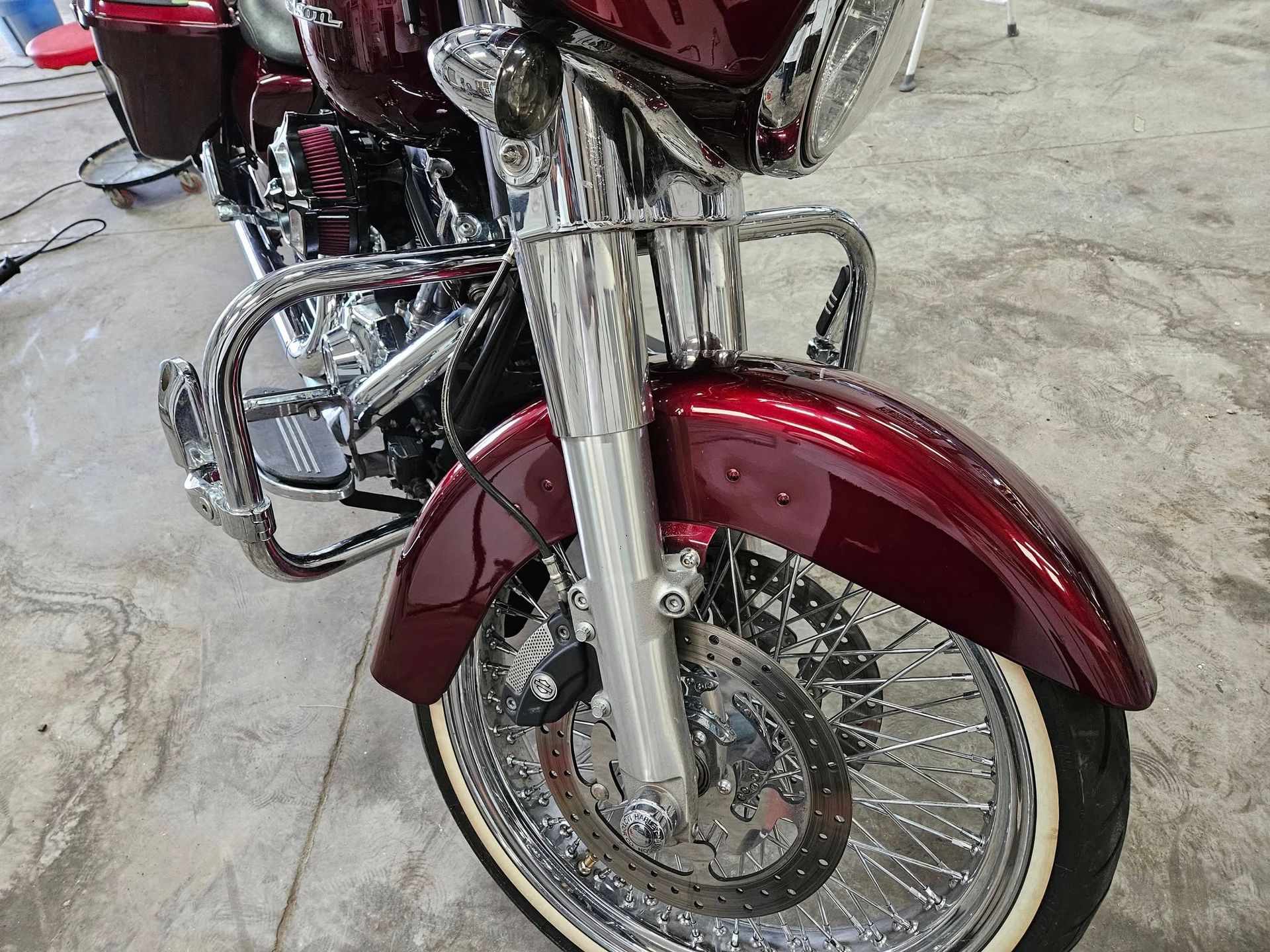 Burgundy motorcycle front view with chrome accents and whitewall tires.