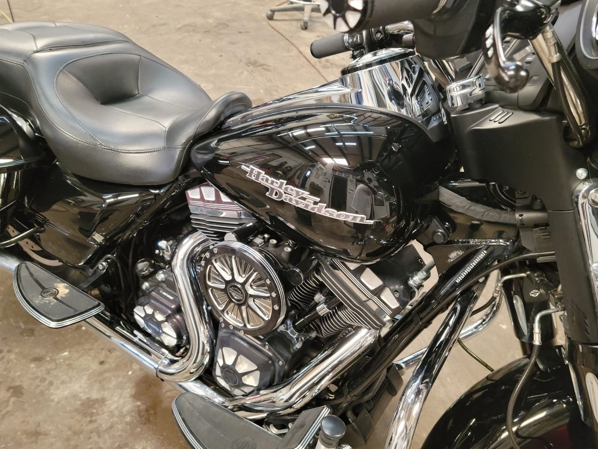 Black Harley-Davidson motorcycle with chrome accents, parked indoors.
