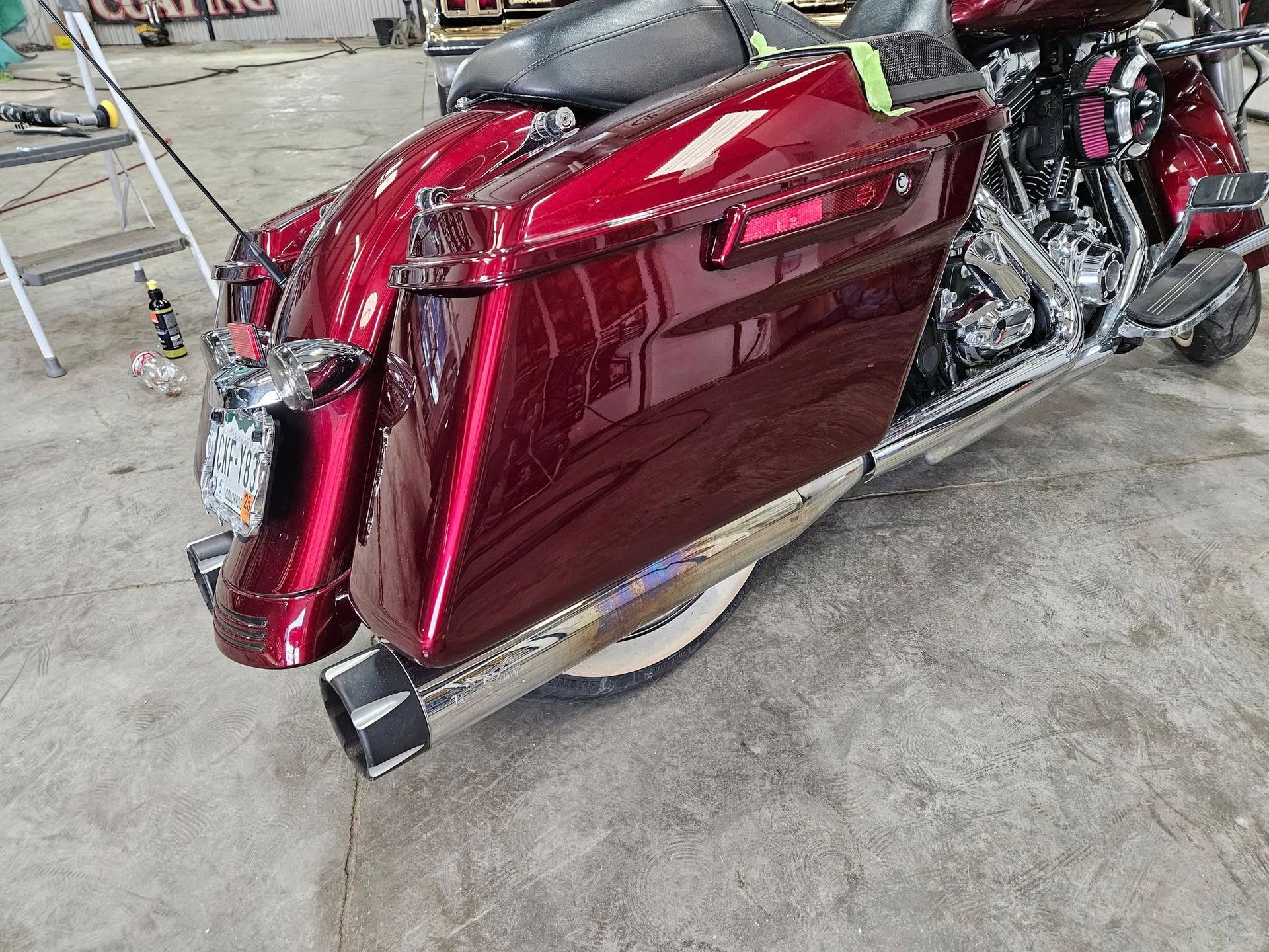 Red motorcycle with chrome accents, sitting on a concrete floor.
