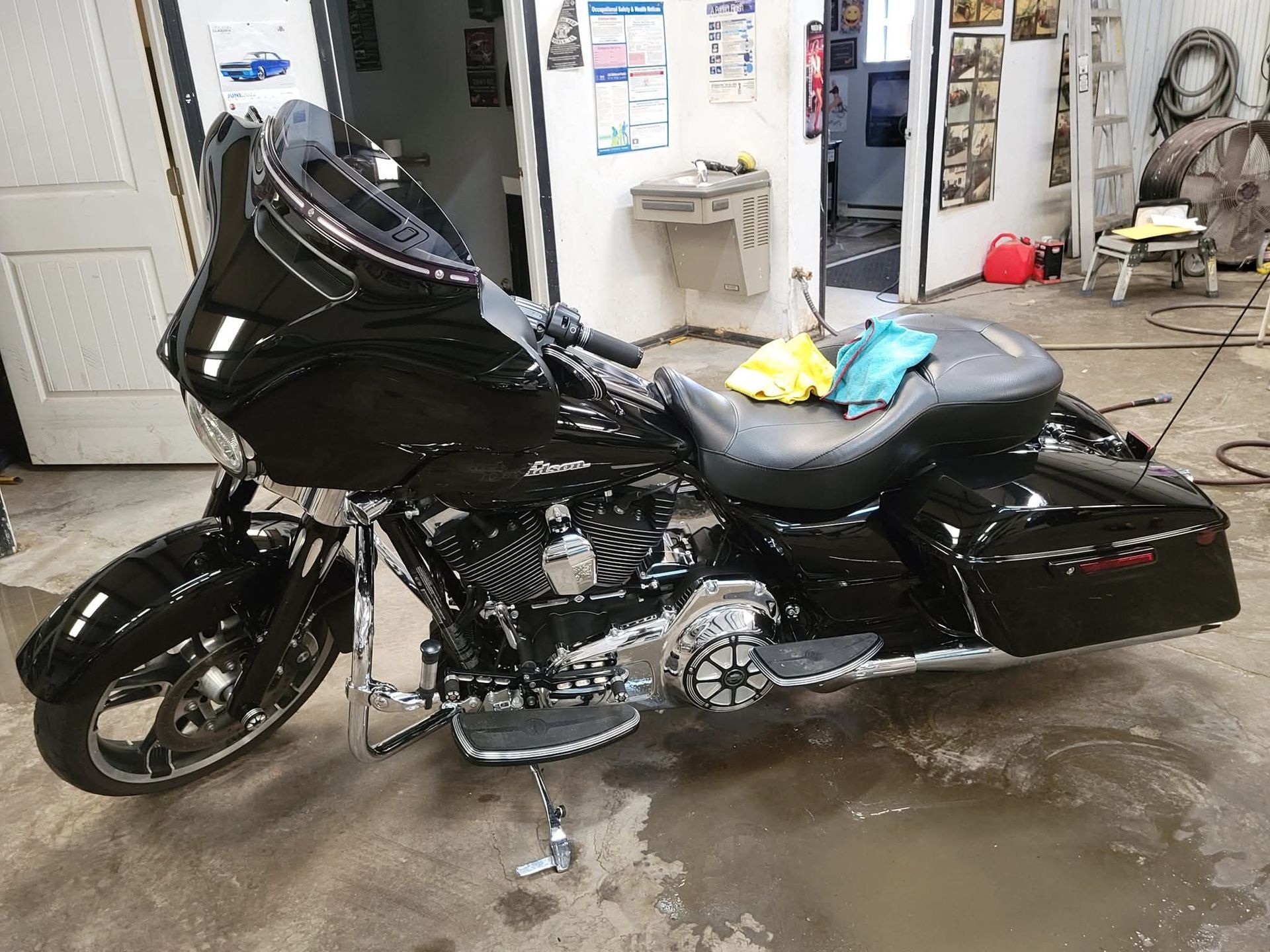 Black Harley-Davidson motorcycle parked indoors, with chrome details and a black seat.