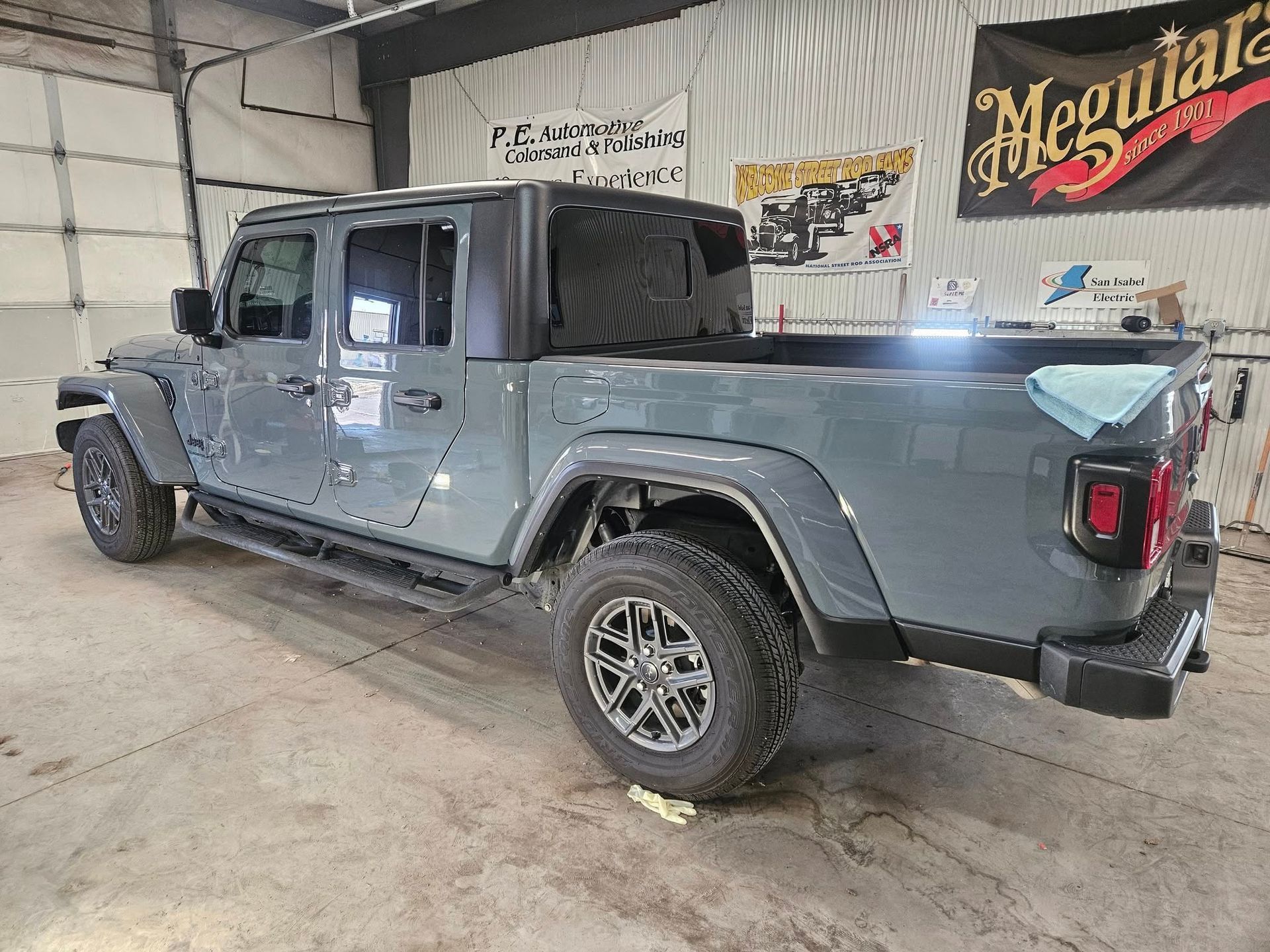 Gray Jeep Gladiator truck in a garage with black wheels.