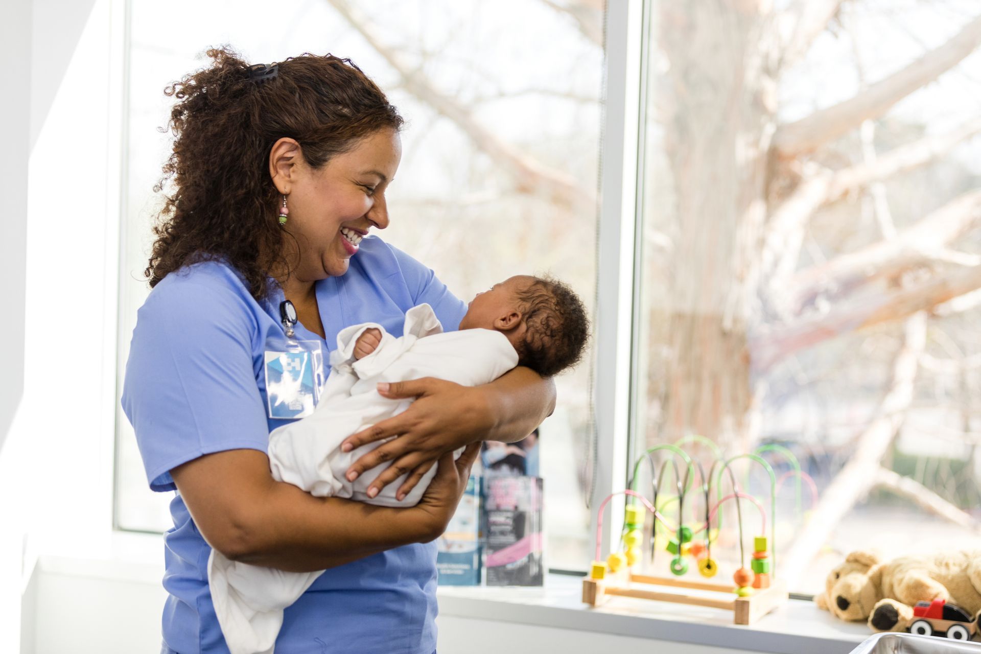 A row of newborn babies sleeping in cribs in a hospital.