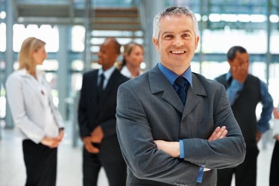 A man in a suit is standing in front of a group of people