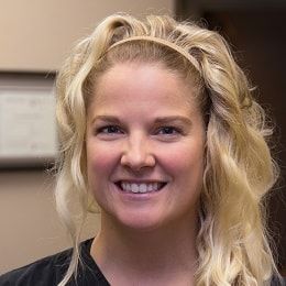 A woman with blonde hair and a headband is smiling for the camera.