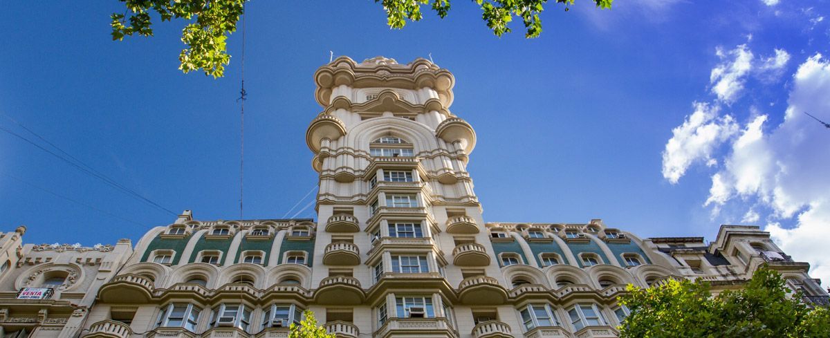 Un edificio alto con un cielo azul de fondo.