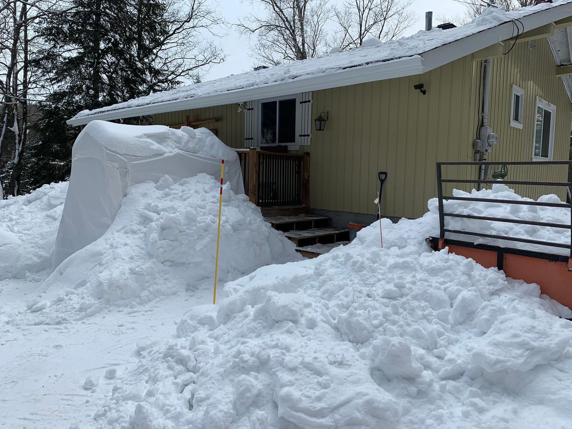 Un gros tas de neige se trouve devant une maison.