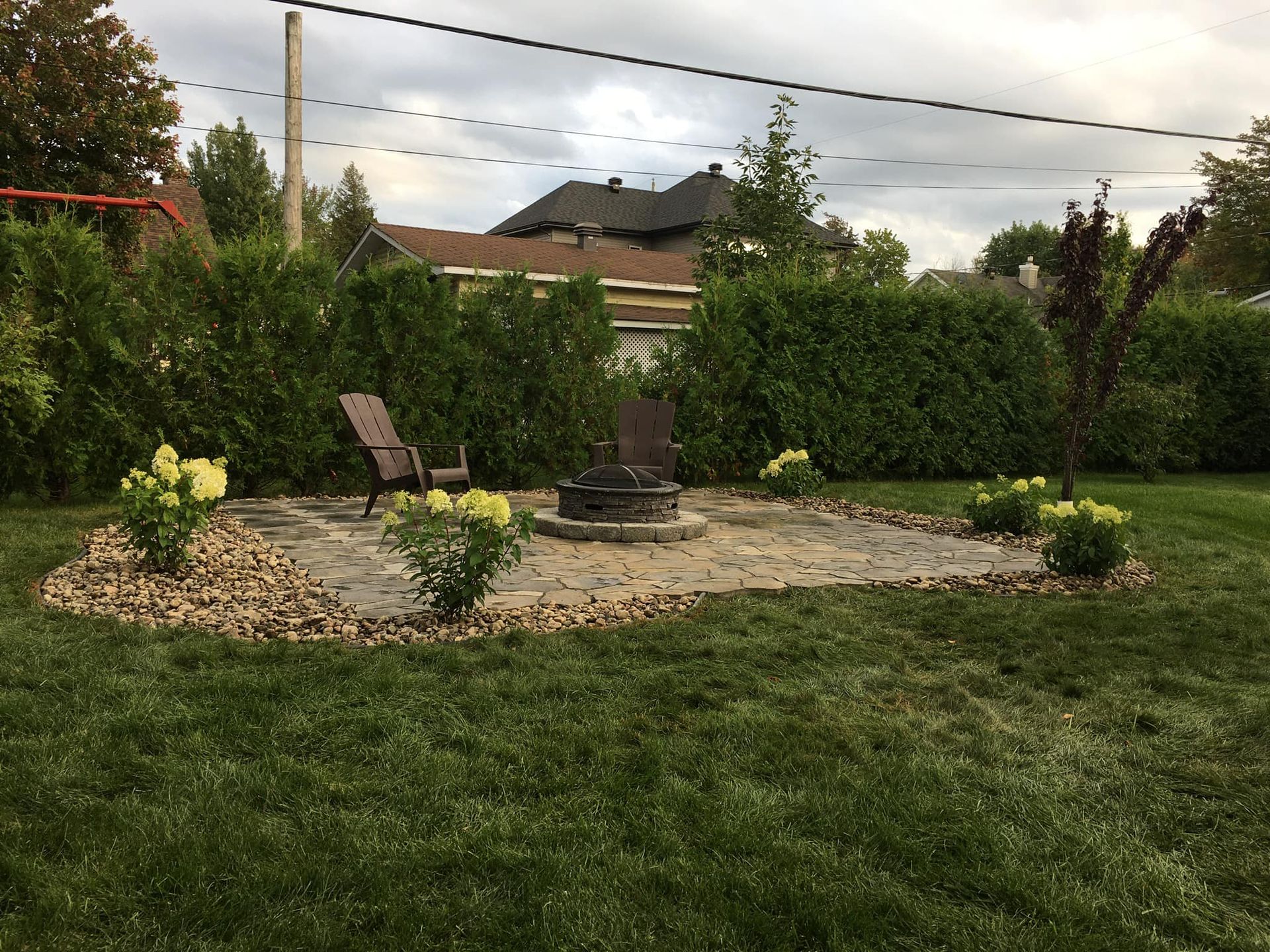 Un foyer se trouve au milieu d'une cour verdoyante.