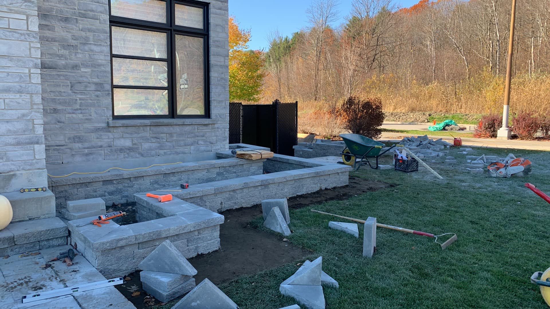 Un mur de briques est en construction devant une maison.