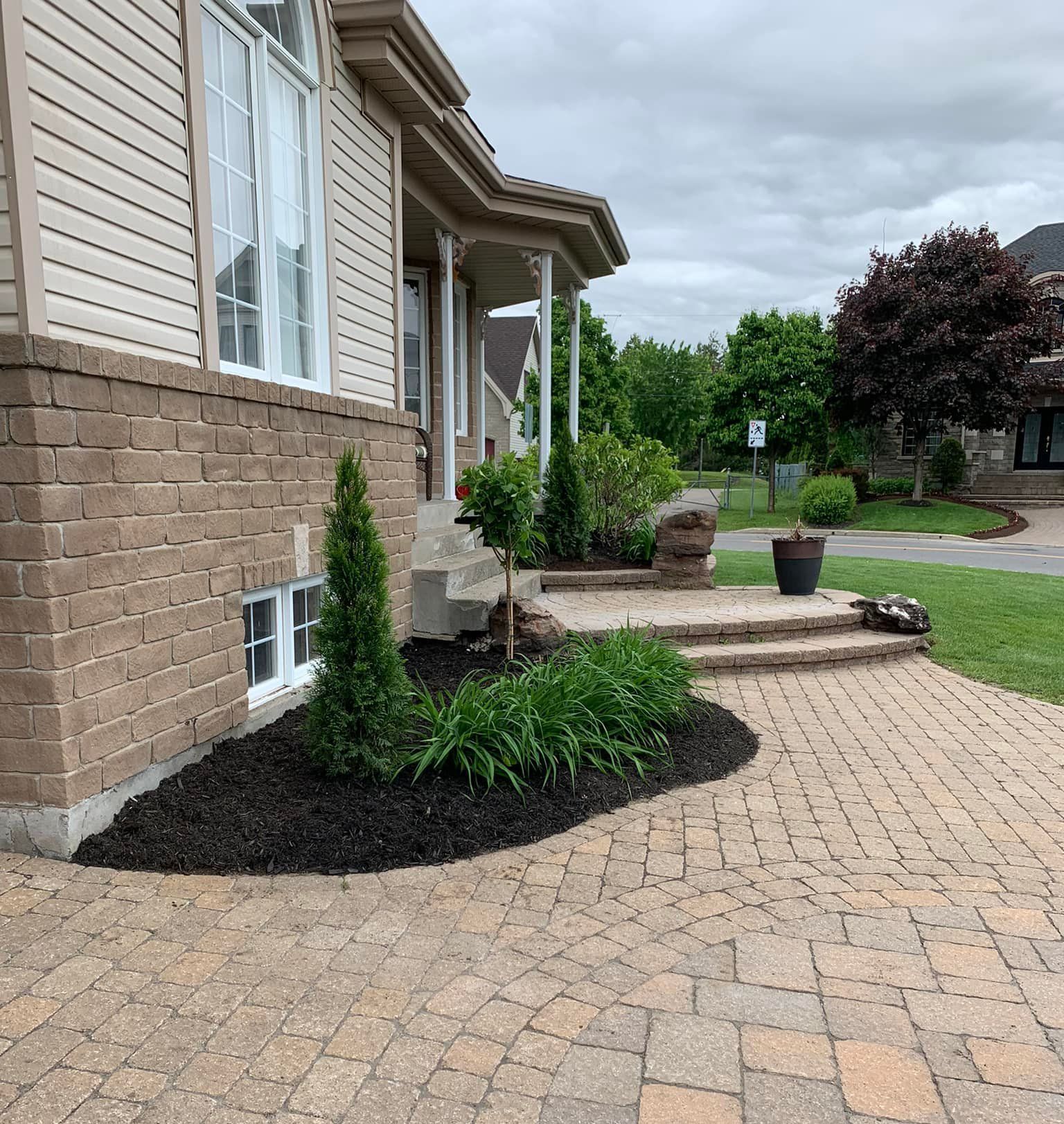 Une maison avec une passerelle en brique menant à la porte d'entrée