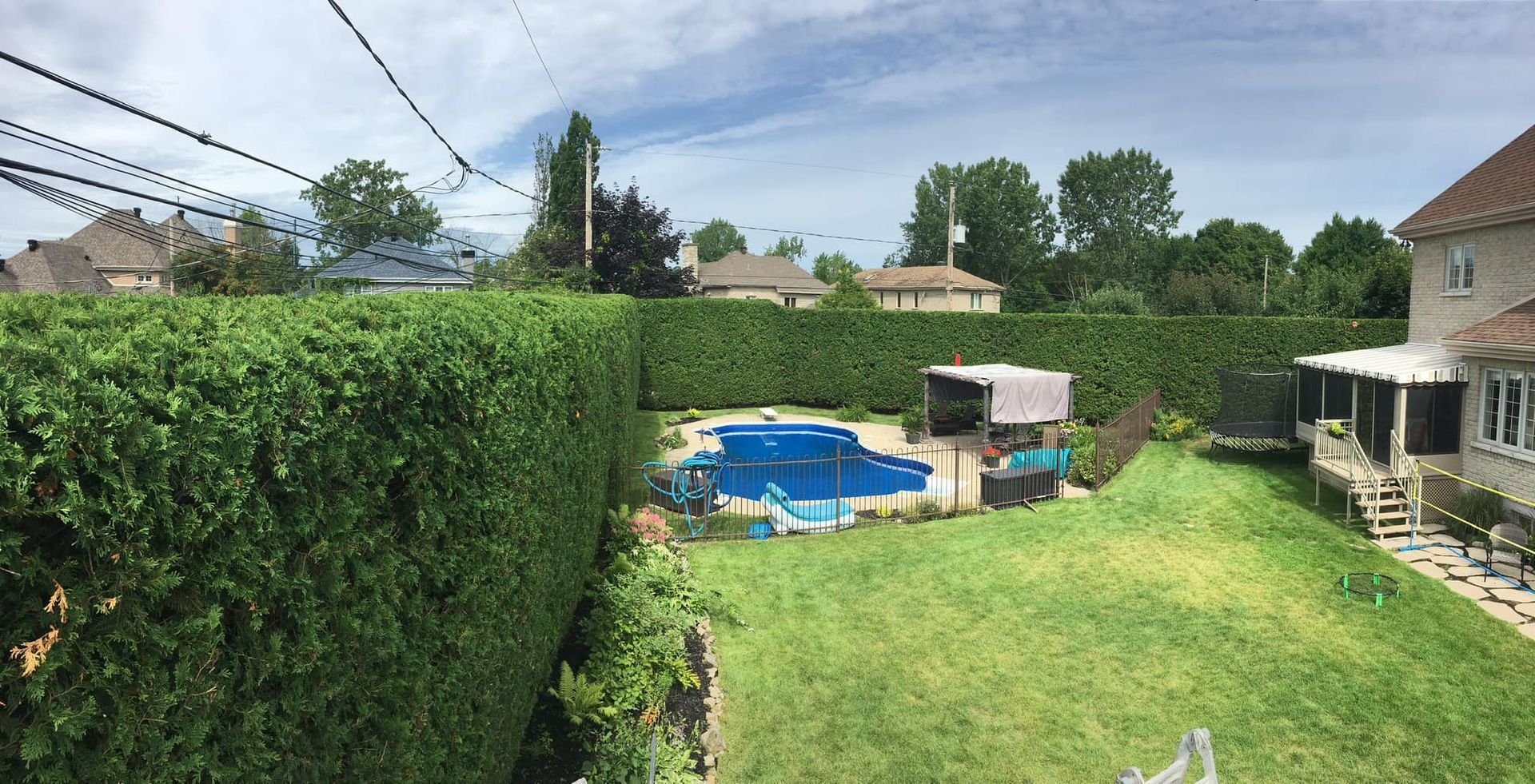 Une grande cour avec une piscine et une maison en arrière-plan.