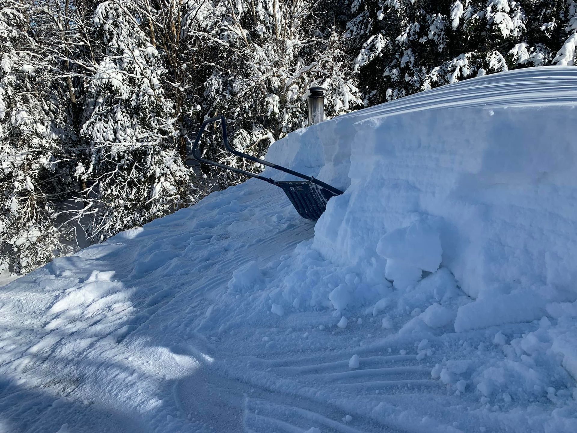 Une pelle à neige est posée au sommet d'un tas de neige.