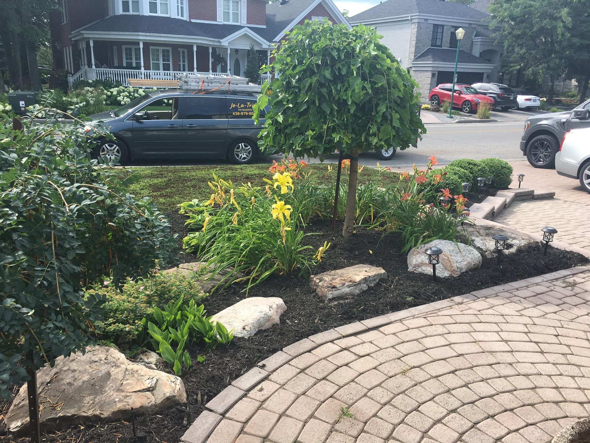 Une camionnette noire est garée dans l'allée d'une maison.