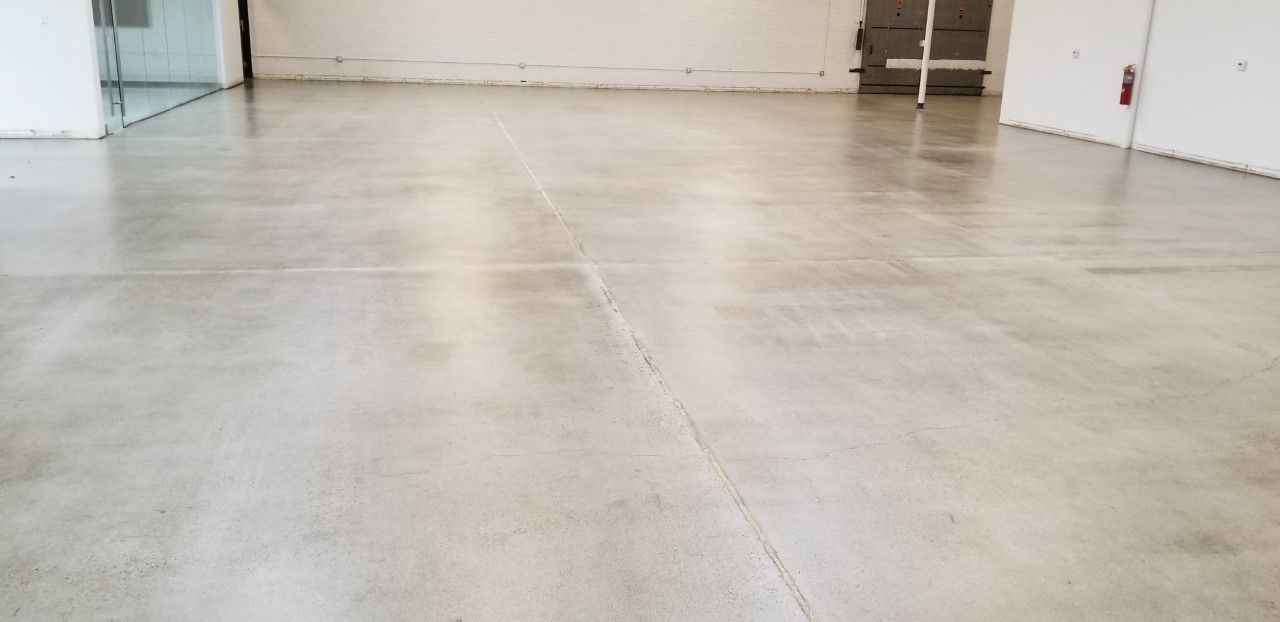 An empty room with a polished concrete floor and white walls.