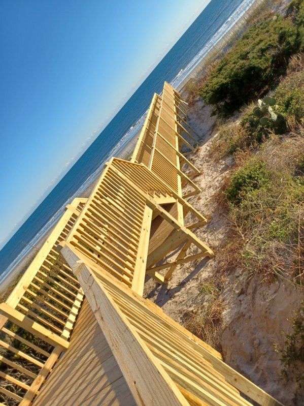 A wicker chair and umbrellas are sitting next to a swimming pool.