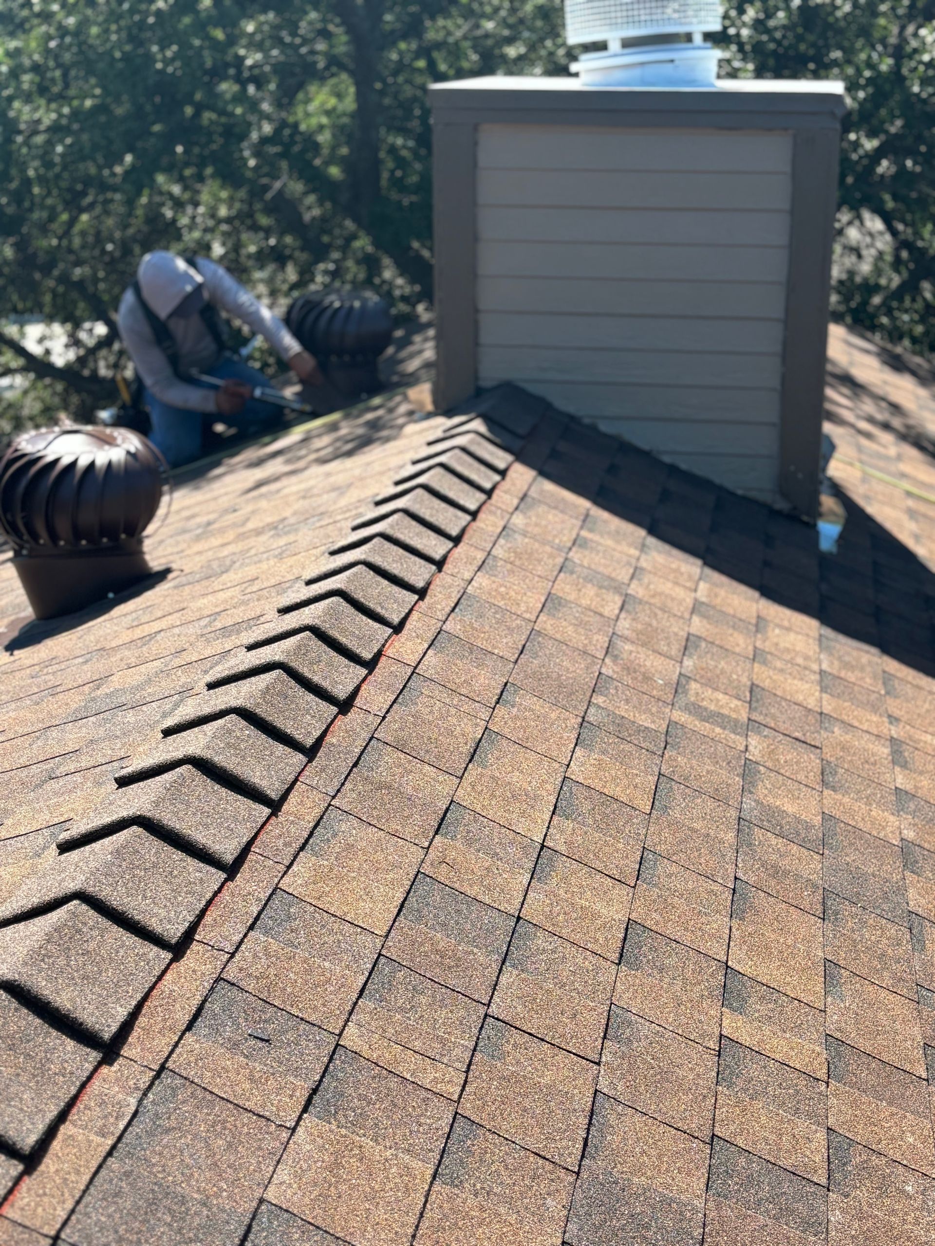 A man is working on the roof of a house.