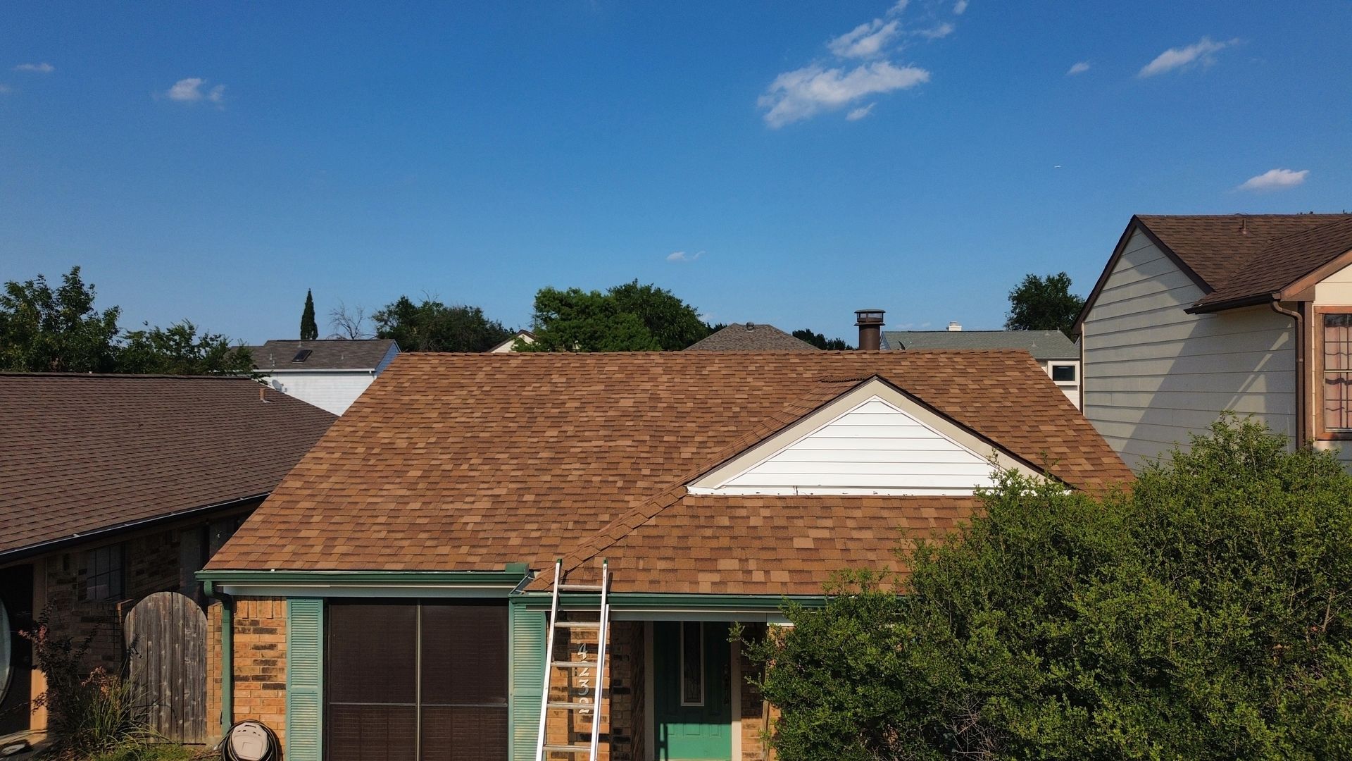 A house with a ladder in front of it is being remodeled.