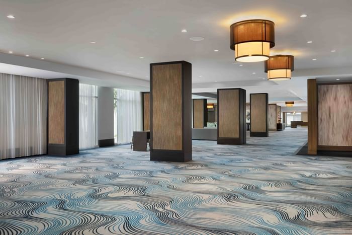 A long hallway with columns and a blue carpet.