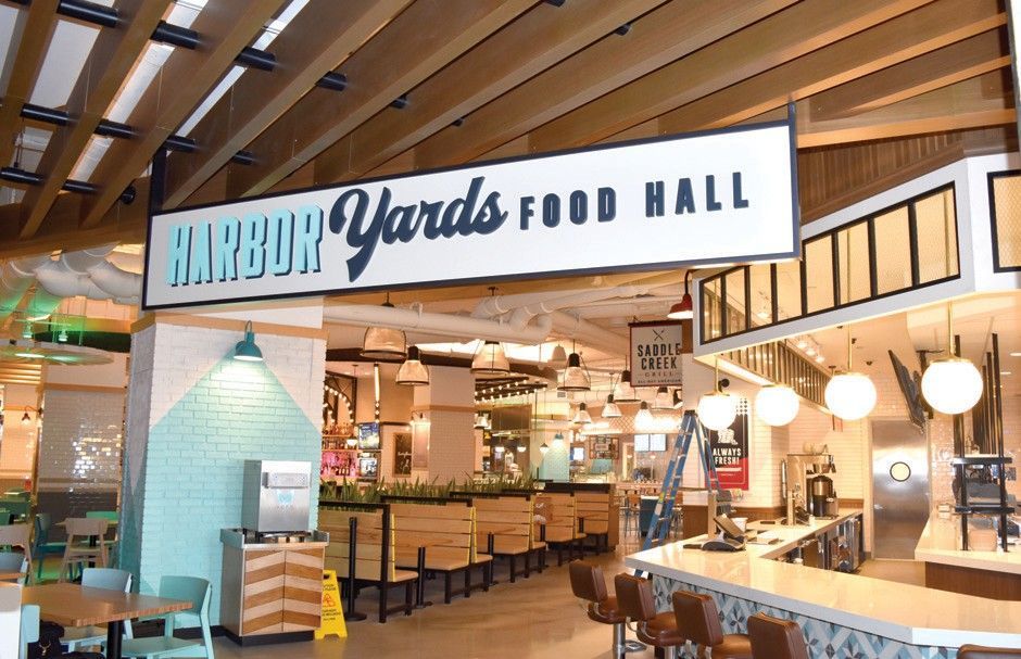 A harbor yards food hall with tables and chairs