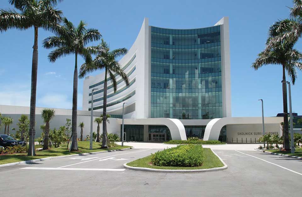 A large white building with palm trees in front of it