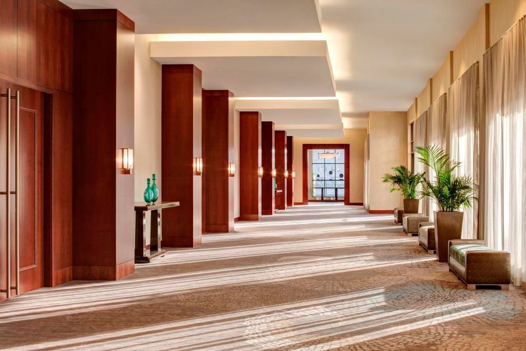 A long hallway in a hotel with a lot of windows