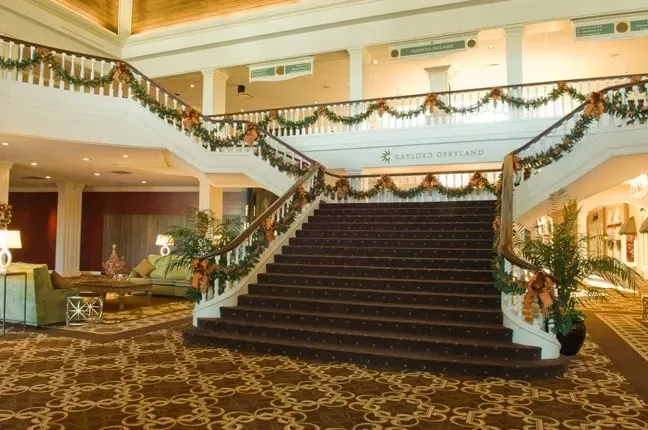 A hotel lobby with stairs decorated for christmas