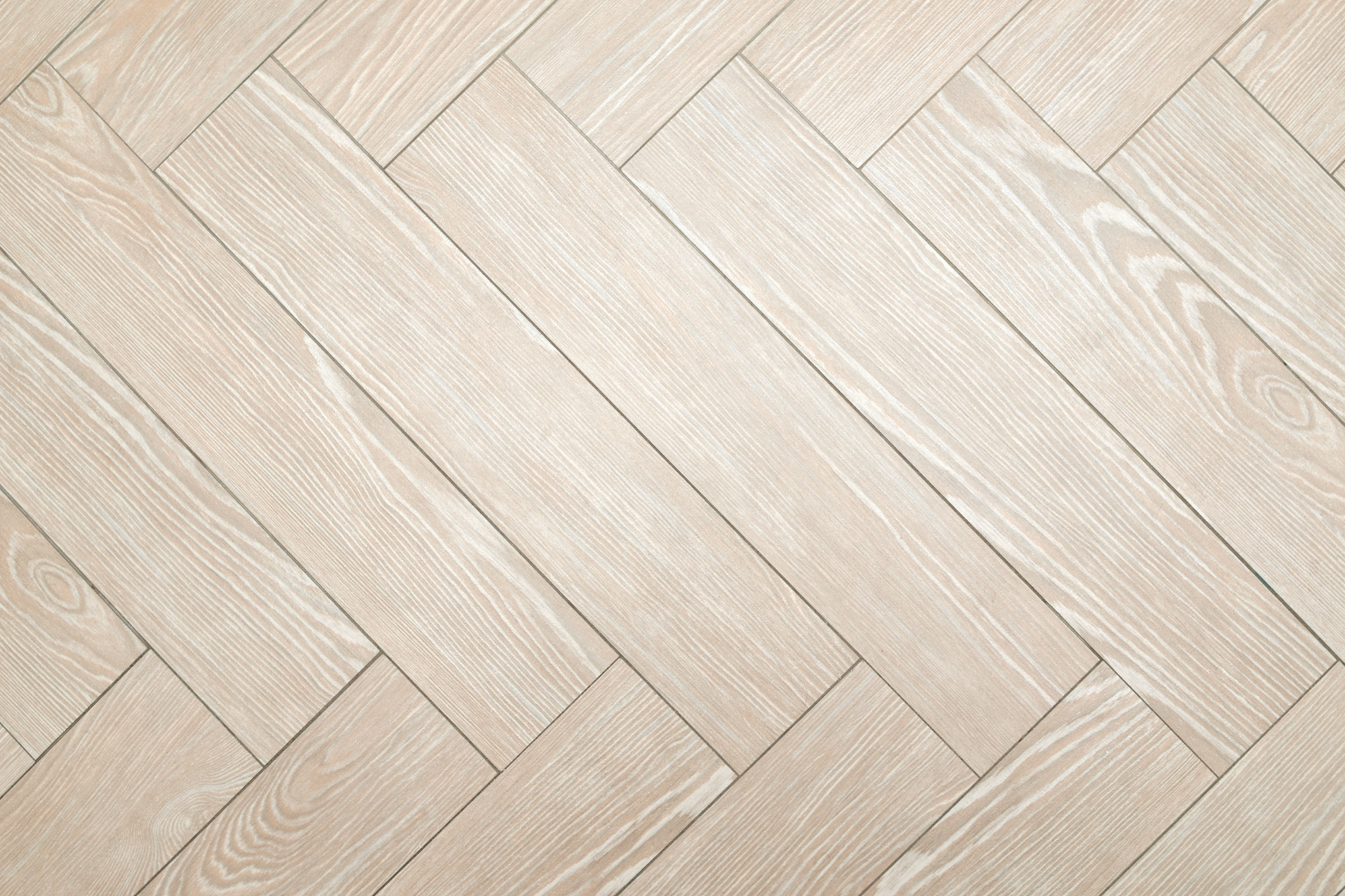 A close up of a wooden floor with a herringbone pattern.