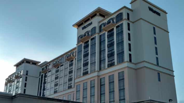 A large white building with a lot of windows against a blue sky.